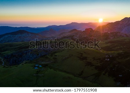Scenic mountain landscape of Peaks of Europe with green hillsides, valleys and highland pastures during sundown, Spain

