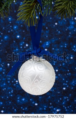 Christmas tree limb with silver glass ornament on star background, Christmas tree