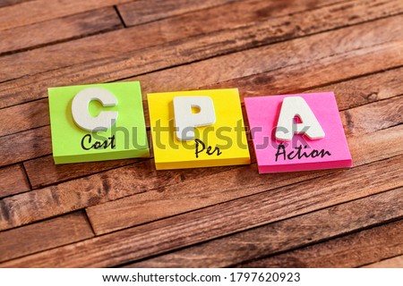 Colorful square papers with wooden white letters for the acronym word CPA Cost Per Action