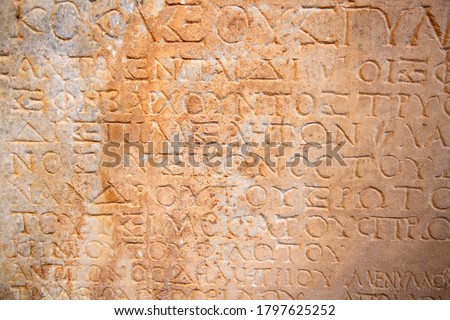 Fragment of the ancient greek letters carved on the stone