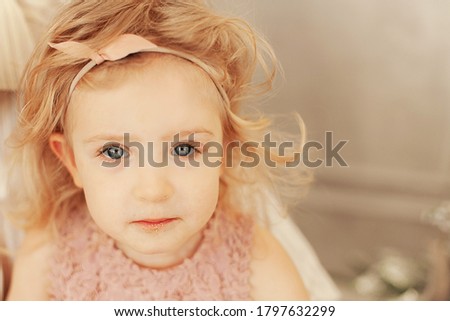 girl blonde curly 3 years old sequins on her face Christmas portrait