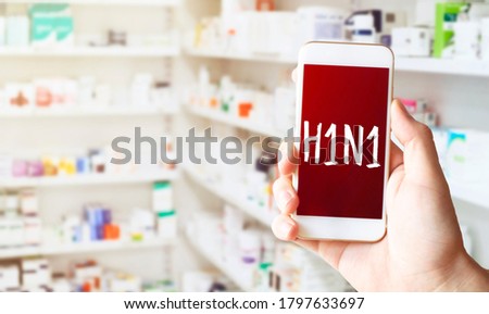 Hand in medical glove holding smartphone on white background. Blank screen with H1N1 text.