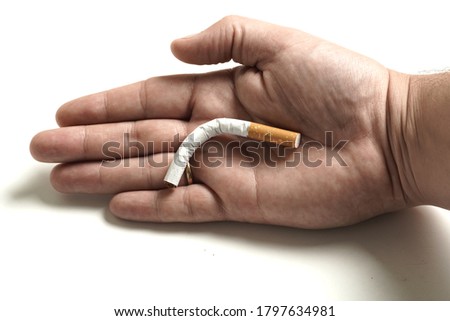 man's hand holding a folded cigarette. impotence concept. flat lay Royalty-Free Stock Photo #1797634981