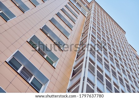Multistorey building. Rhythm in photography. Multi-storey facade, windows and block of flats, close up. Modern apartments in high raised building. Angle perspective.