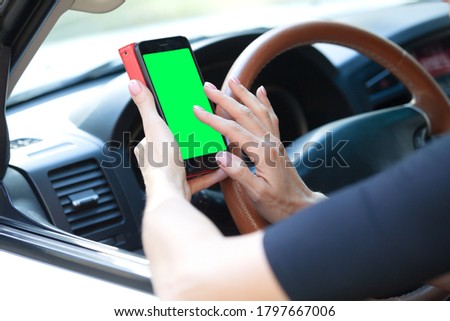 woman driver with a smartphone in her hands while driving. 
