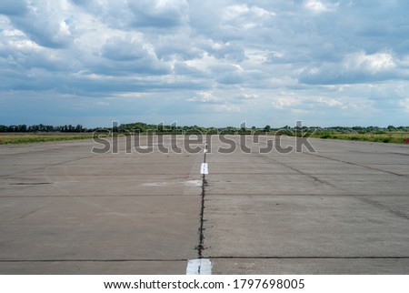Military transport airfield Kryvyi Rih. Empty runway strip and cumulus. Royalty-Free Stock Photo #1797698005