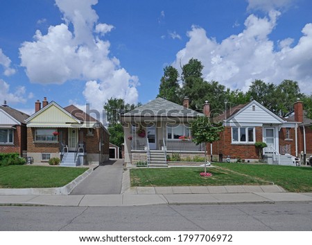 Street with row of modest 1950s style working class bungalows Royalty-Free Stock Photo #1797706972