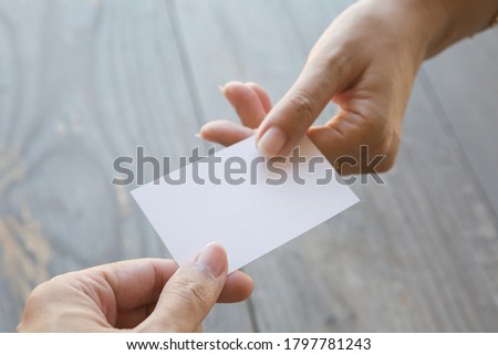 Hand holding Business card on a wood background