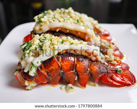 Close up easy homecook meal served several red orange color arranged aligned perfectly cooked garlic butter lobster tails with parley baked or broiled for lunch and dinner at home Royalty-Free Stock Photo #1797800884
