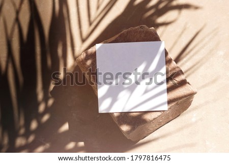 Blank paper sheet cards template, stone and sunlight palm shadows on beige textured background. Flat lay, top view.copy space. Business podium mock up .