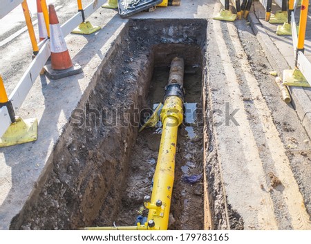 Underground pipe being fixed in trench Royalty-Free Stock Photo #179783165