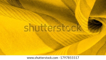 Texture. Background. Silk fabric of yellow color, of the color between green and orange in the spectrum, a primary subtractive color complementary to blue; colored like ripe lemons or egg yolks.