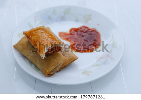 Selective focus picture of "popiah otak-otak" in the plate. Fish cake made of ground fish meat mixed with tapioca starch and spices in spring rolls.