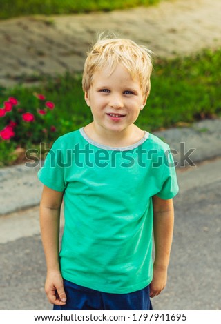 Happy mischievous cheerful cute blond boy with freckles face playing outside, laughing. Behaviour education problems psychology, family relationship, daycare activity, simple joys of happy childhood