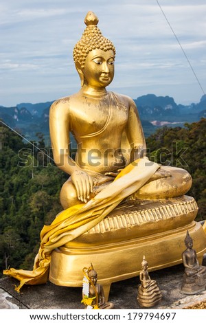 Seated golden Buddha statue at hilltop temple in Krabi, Thailand. Photo taken July 5, 2013