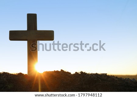Wooden Christian cross outdoors at sunrise, space for text. Religion concept