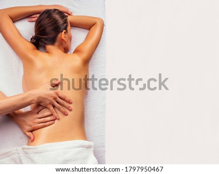 woman lying on the table and getting ayurvedic massage with organic oil or honeyed in dark room.massagist making yoga massage Royalty-Free Stock Photo #1797950467