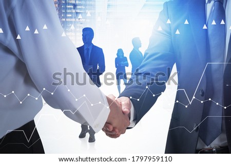 Close up of two unrecognizable businessmen shaking hands in blurry office. Concept of partnership. Toned image double exposure of graph
