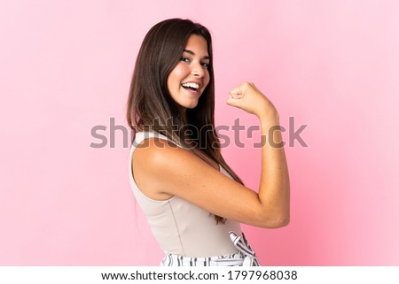 Young brazilian woman isolated on pink background doing strong gesture Royalty-Free Stock Photo #1797968038