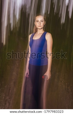 Strange portrait of beautiful cheerful redhead girl. Motion effect, background blurred. Depression concept.