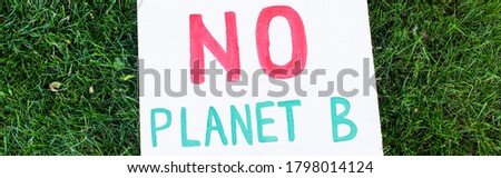 Panoramic shot of placard with no planet b lettering on green grass, ecology concept