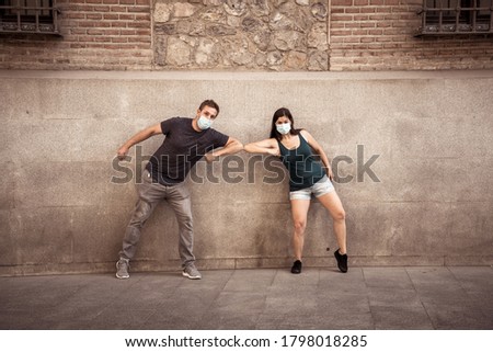 The New Normal and greeting style. Man and woman Shaking elbows or feet keeping social distancing to avoid Coronavirus spread. COVID-19 outbreak and disease protection.