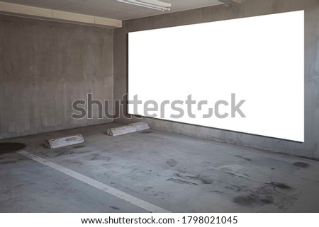 Large blank billboard on the wall of the basement car park