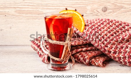 Mulled wine Hot christmas drink with spices on wooden background. Orange slice, cinnamon sticks, sweater. Christmas morning. Holiday atmosphere, Rustic style. The idea for creating greeting cards