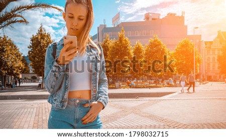 Taking picture. Happy young girl with phone smile, typing texting and taking selfie in summer sunshine urban city. Pretty female taking fun self portrait photo. Vanity, social network concept.