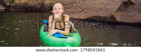 Side view picture of a woman sitting and relaxing on the sup board. Surfer woman resting BANNER, LONG FORMAT