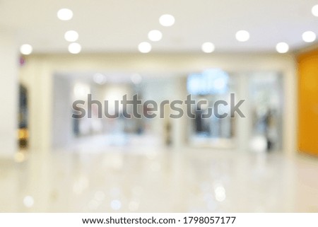 Abstract blurred shopping mall interior background. Blur aisle of supermarket for backdrop and design element use. Defocused background with bokeh light.
