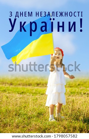 Text on Ukrainian Happy Independence Day. Ukraine s blue-yellow flag flying in wind in hands of little Ukrainian girl . Symbols of Ukraine in hands of a smiling child