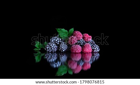 Frozen organic raspberry and blackberry berries covered with hoarfrost. Frozen products. Steamy cold frozen fruit. black background. Healthy vegetarian diet. Freshly from the fridge