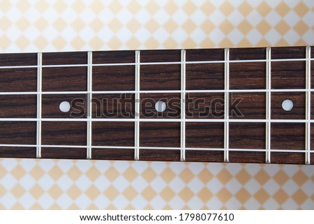Ukulele neck. Guitar strings and frets Royalty-Free Stock Photo #1798077610