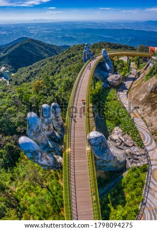 Aerial view of the Golden Bridge is lifted by two giant hands in the tourist resort on Ba Na Hill in Da Nang, Vietnam. Ba Na mountain resort is a favorite destination for tourists Royalty-Free Stock Photo #1798094275