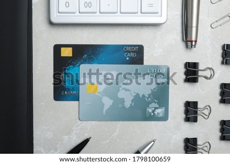 Flat lay composition with credit cards, calculator and stationery on light grey marble background