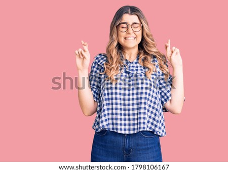 Young caucasian woman wearing casual clothes gesturing finger crossed smiling with hope and eyes closed. luck and superstitious concept. 