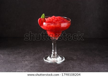 Strawberry margarita cocktail in glass on black background
