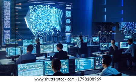 Team of Professional Computer Data Science Engineers Work on Desktops with Screens Showing Charts, Graphs, Infographics, Technical Neural Network Data and Statistics. Dark Control and Monitoring Room. Royalty-Free Stock Photo #1798108969