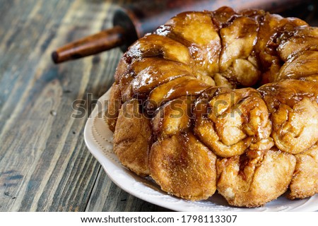 Dessert of Pull Apart Carrot Cake Monkey Bread. A yeast bundt cake made with cinnamon, carrots, nuts and a brown sugar glaze. Selective focus with blurred foreground and background.