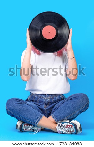 Woman dj portrait with vinyl record against blue background. Retro picture of woman with vinyl record