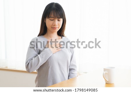 Young woman putting her hands on her chest, shot in the studio