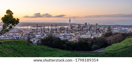 Panoramic view of Auckland city skyline with Auckland Sky Tower from Mt. Eden at sunset New Zealand Royalty-Free Stock Photo #1798189354