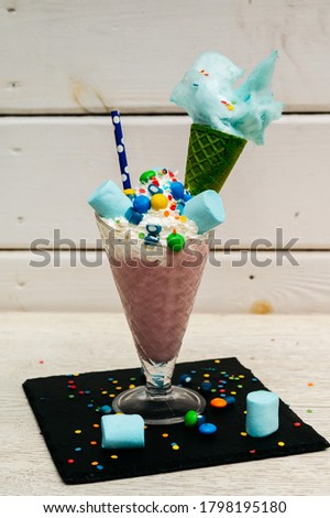 Marshmallow candy milk shake cocktail or freak shake with whipped cream and other treats.