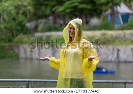 Portrait of the women wearing yellow raincoat while raining in rainy season Royalty-Free Stock Photo #1798197445