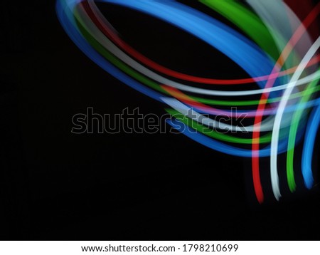 Mixture colurs (Green, red, white, blue) light painting photography, long exposure, ripple circle and waves against black background