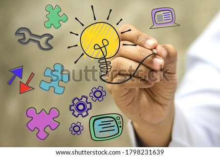 Hand holding a pen to write ideas according to imagination.Mastering technology and solving puzzles