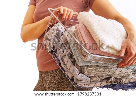 woman holds laundry in hands , soot in pastel colors. bright picture of lovely housewife with towels.