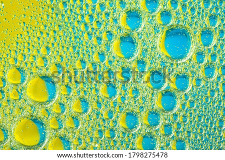 Psychedelic blueand yellow oil and water abstract background. Abstract colorful background. Foam of Soap with Bubbles macro shot. Closeup bubbles in water. Oil drops on a water surface blue and yellow