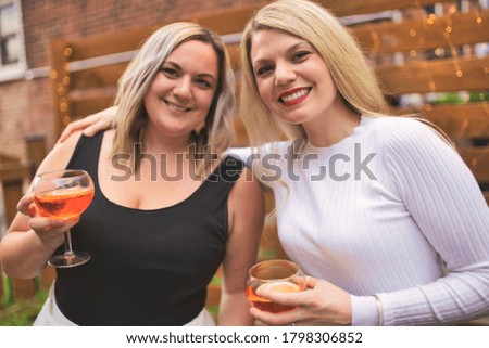 A happy girls friends drinking drink having fun outside